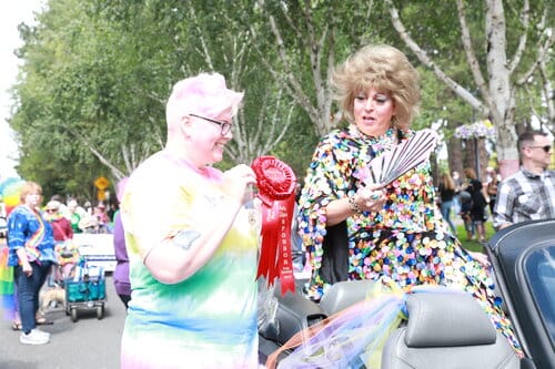 pride parade award being given to person with hand fan pride parade award being given to person with hand fan