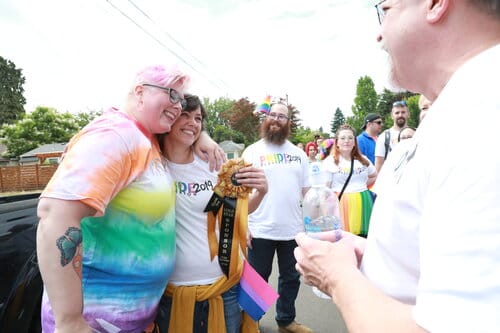 small group of happy people showing ribbon and hugging small group of happy people showing ribbon and hugging