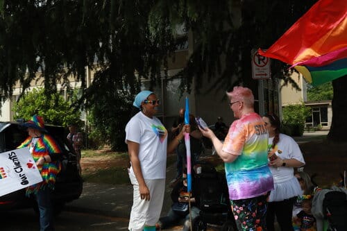 small group of people holding pride flags small group of people holding pride flags